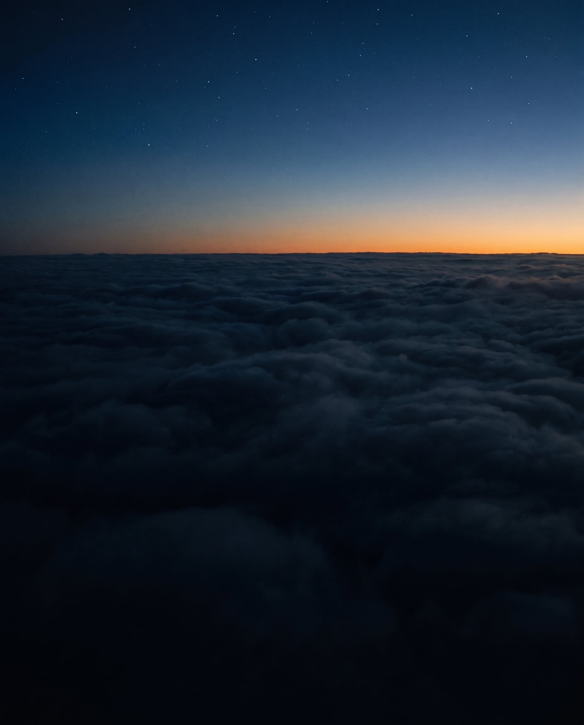A clear horizon line above a still cloud layer at first light.